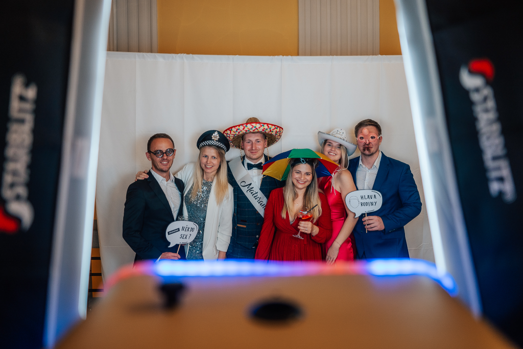 Hosté s rekvizitami pózují před fotobudkou MemoryCube.